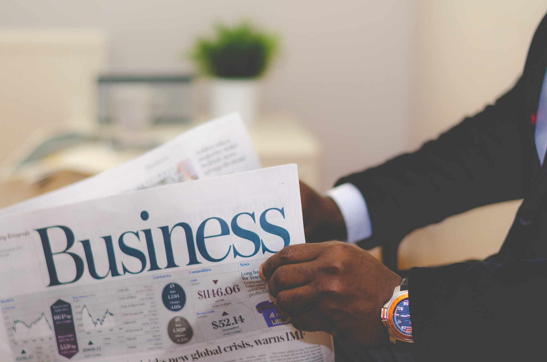 Man holding business section of newspaper